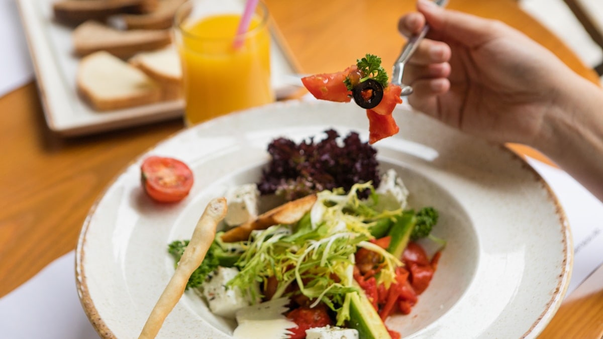 Woman eating beautiful vegetarian salad close up